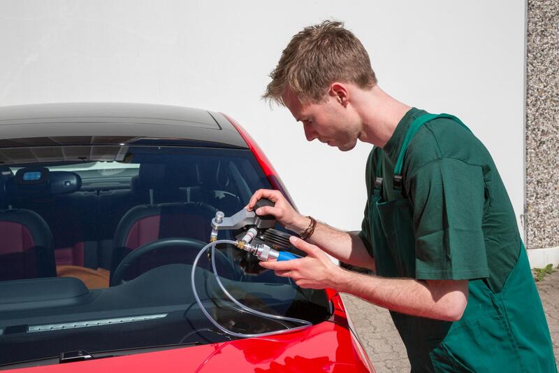 Auto glass technician working on a vehicle