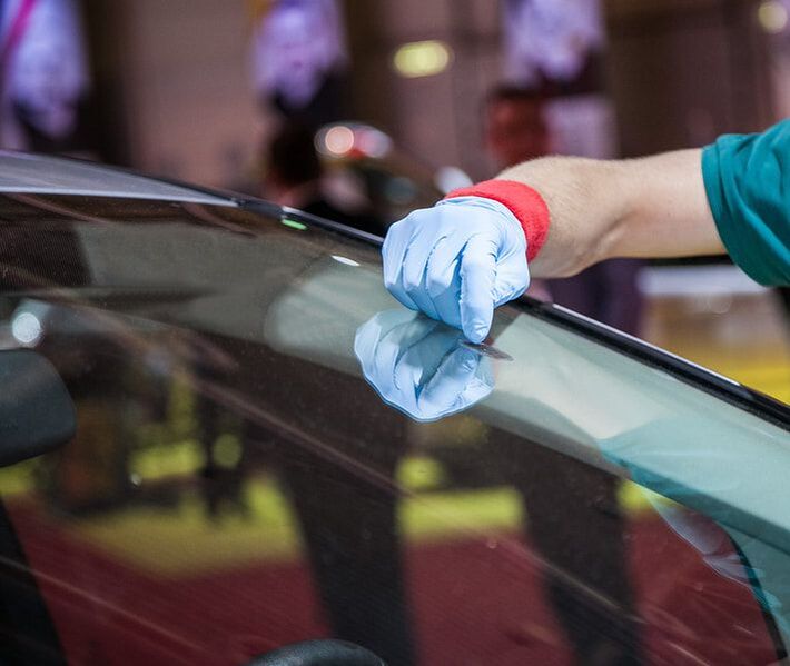 Auto glass technician working on a vehicle