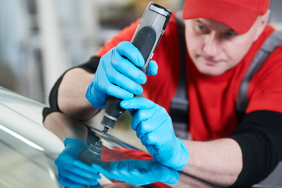 Auto glass technician working on a vehicle